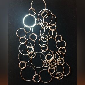 Fabulous and unusual long necklace with varying sizes of circles. Silver tone.